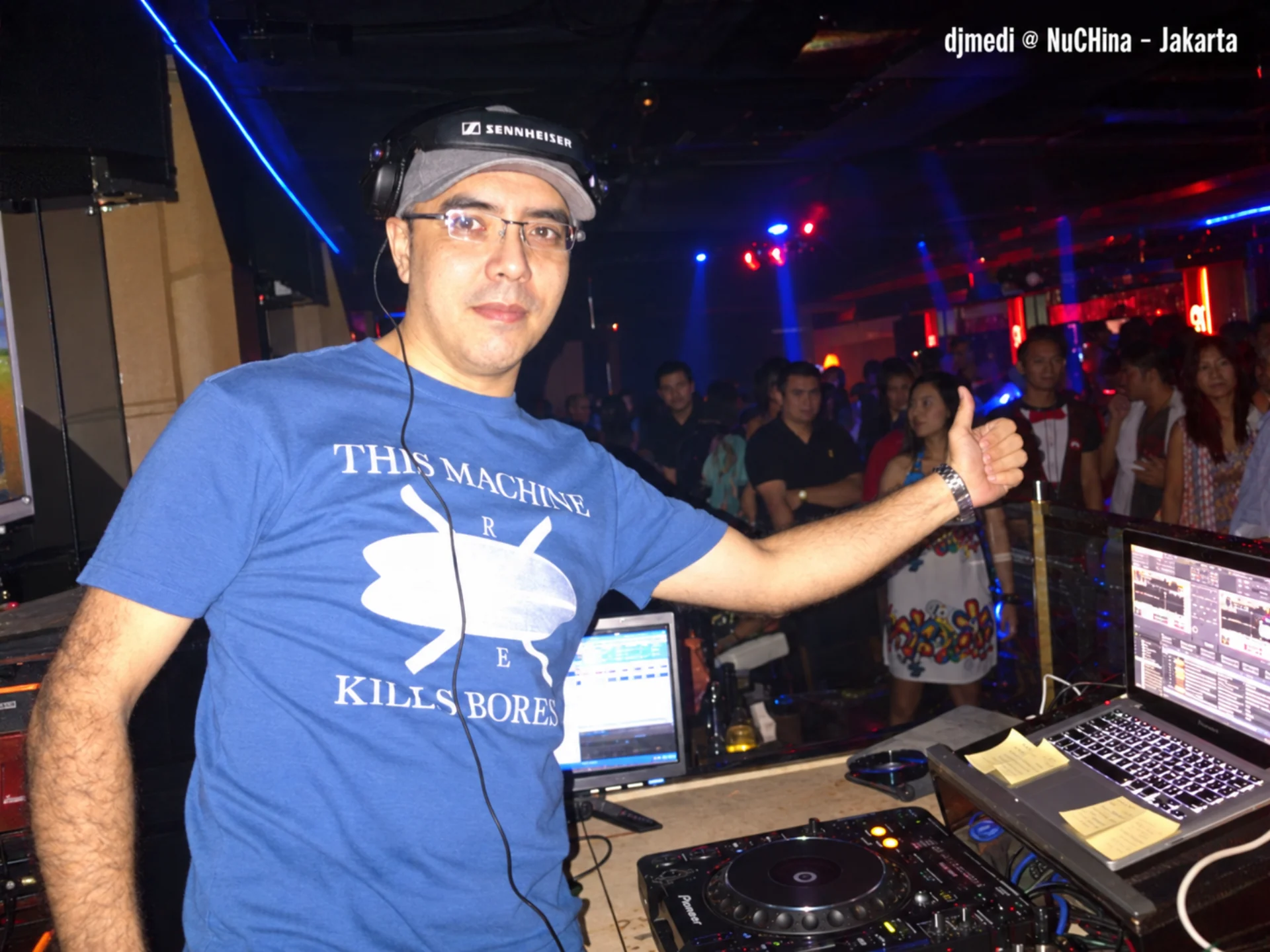 DJ M3DI behind the decks at Nu China in Jakarta, giving a thumbs-up.
